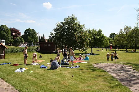 Liegewiese mit Badegästen bei schönem Wetter im Freibad Einbeck