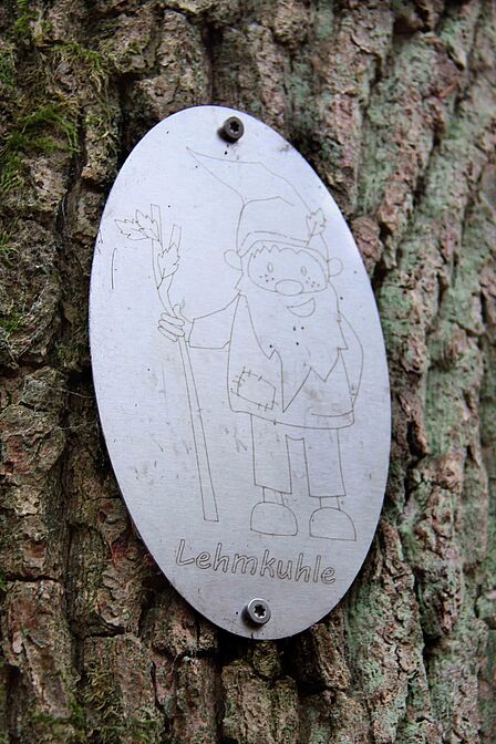 Silberne Plakette mit einem Waldzwerg darauf und der Unterschrift Lehmkuhle