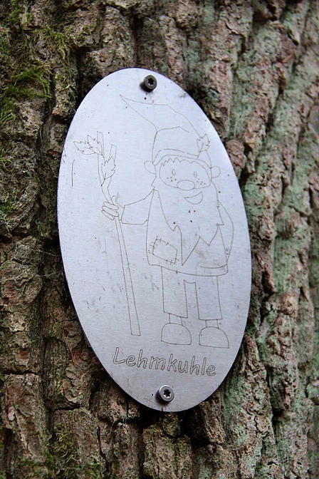 Silberne Plakette mit einem Waldzwerg darauf und der Unterschrift Lehmkuhle