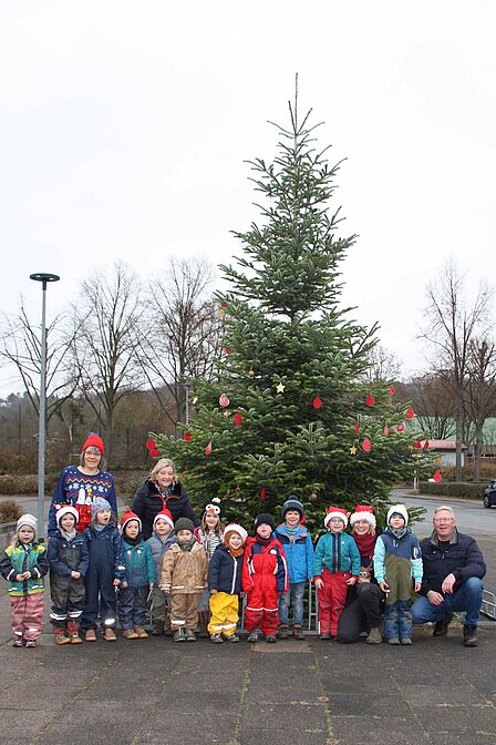 Gruppenaufnahme der Waldzwerge vor einem geschmückten Weihnachtsbaum.