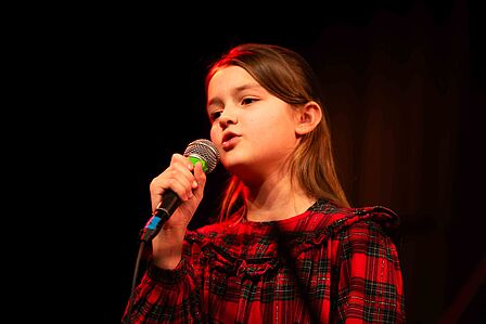 Junges Mädchen singt mit Mikrophon