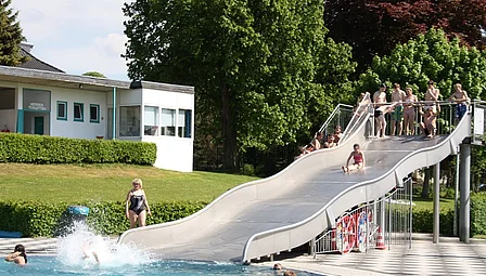 Wasserrutsche im Freibad Einbeck die bei schönem Wetter ins Wasser rutschen.