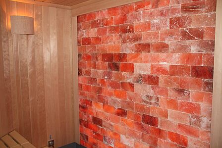 Wand aus roten Salzsteinen umgeben von Holzverkleidung.