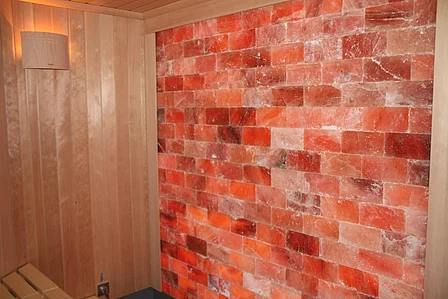 Wand aus roten Salzsteinen umgeben von Holzverkleidung.